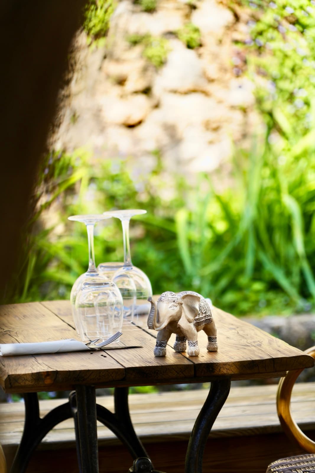 Un petit éléphant en bois posé près des verres, souvenir de voyage